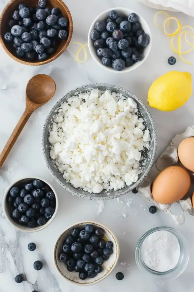 Blueberry Cottage Cheese Breakfast Bake 7 Bowls of blueberries, eggs, and cottage cheese ingredients