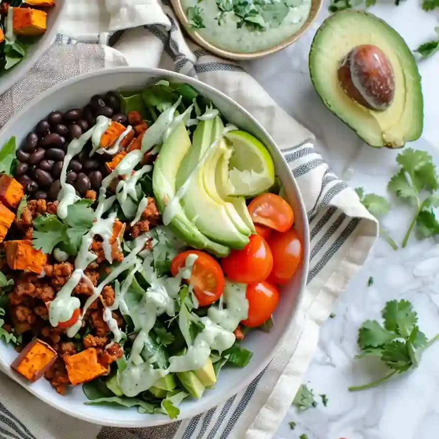 Sweet Potato Taco Bowls with fresh vegetables and avocado on striped towel